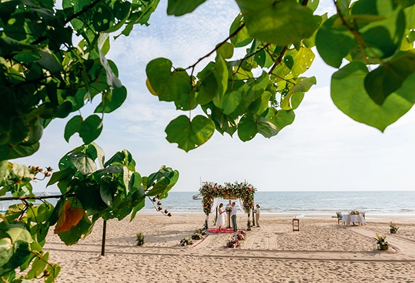 Trauung am Strand des Pimalai Resort & Spa auf Koh Lanta mit floralem Traubogen und Blick auf das Meer