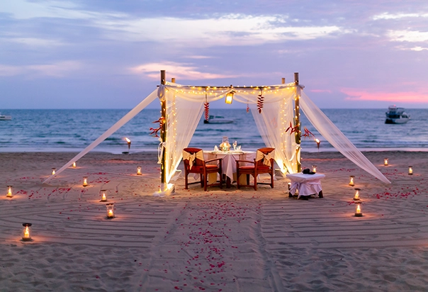 Romantisches Hochzeitsdinner unter einem Pavillon mit Lichterketten am Strand des Pimalai Resort auf Koh Lanta