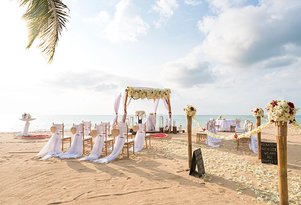 Hochzeitsdekoration mit floralem Traubogen in Weiß für eine Strandhochzeit in Khao Lak, Thailand
